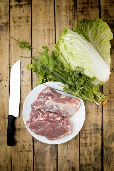Сырая свинина и овощи на деревянном столе . — стоковое фото