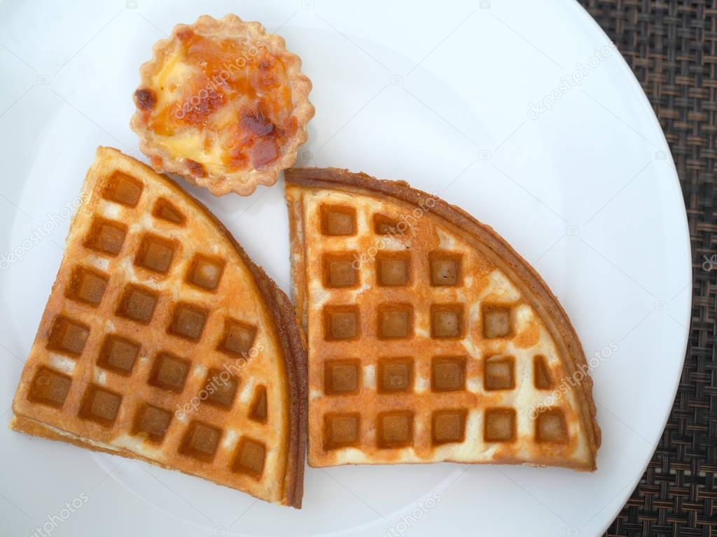 Waffle on white dish. Flat top view.