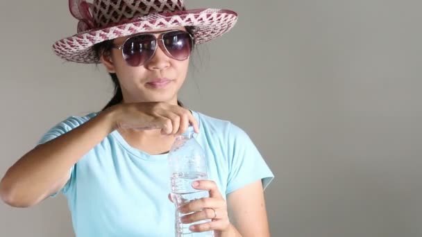 Mujer en sombrero de paja bebe agua de la botella de plástico . — Vídeos de Stock