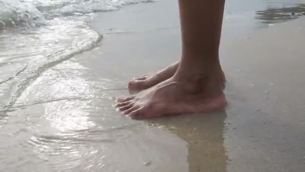 Mujer pierna de pie en la playa en el océano — Vídeo de stock
