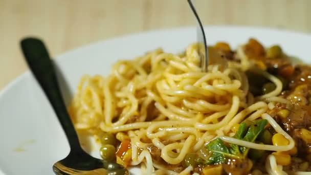 Espaguetis de cuchara de tenedor sobre plato en mesa de madera . — Vídeo de stock