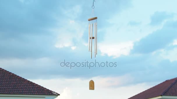 Wind chime tube mobile in breeze, Home village background. — Stock Video