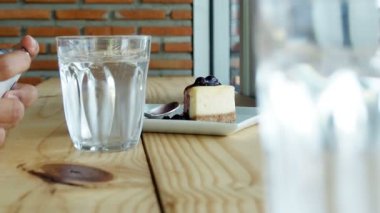 Smartphone, buzlu kahve, çay, su cam ve pasta bardaki Asyalı kadın