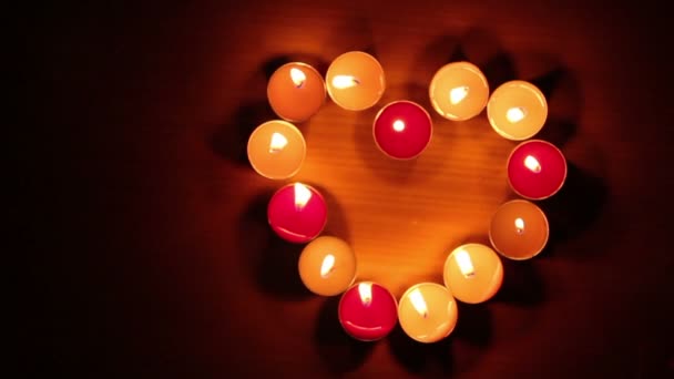 Luce di candele a forma di cuore, sfondo nero . — Video Stock