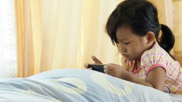 Aziatische meisje smartphone thuis spelen. — Stockvideo