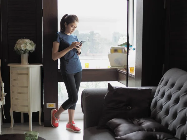 Asian woman relax, texting on mobile phone.