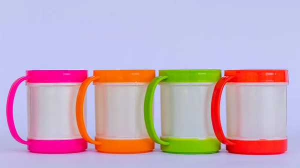 Quattro Tazze Caffè Colorate Plastica Allineate Uno Sfondo Bianco — Foto Stock