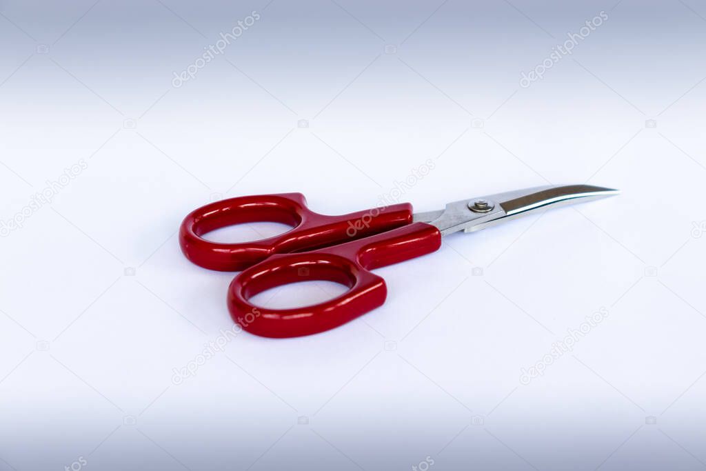 Red handle Silver curved Scissor on a white paper