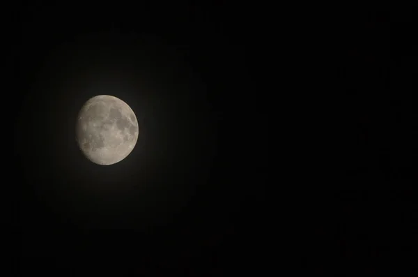 The moon is almost full with black background.