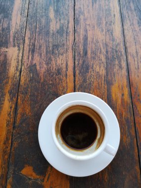 Tahta masanın üzerinde fotokopi alanı olan bir fincan kahve..