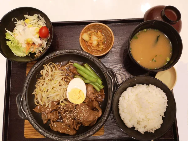 Japanese food is placed in wooden box on the table.