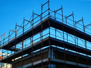 Bir binanın mavi gökyüzü şantiyesiyle saray iskelesi. 