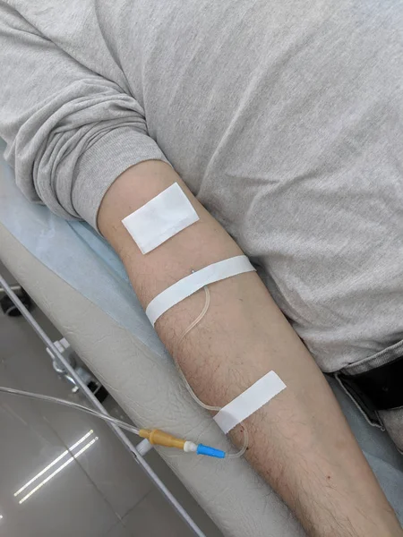 IV drip (intravenous drip - phleboclysis) needle in arm of a male patient