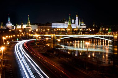 Moskova 'nın Kremlin' i geceleri Moskva nehrinin kenarındaki yolda hafif araba izleri bırakıyor.