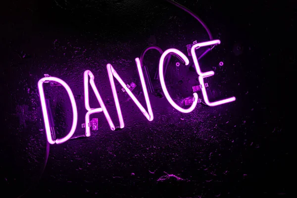 Purple Neon Light Creating Word Dance Black Wall Disco Night — Stock Photo, Image