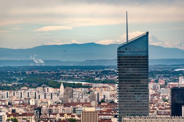 Fransa 'nın başkenti Lyon' un Skyline 'ında arka planda bir uçak, yakınlardaki Bugey Nükleer Santrali' nin soğutucu kulelerinin üzerinde ve Alpler dağlarının önünde.