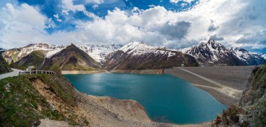 Fransız Alpleri 'ndeki Grand' Maison Gölü Panoraması 'nda sağında Grand' Maison barajı var. Göl, pompalı bir hidroelektrik şemasında üst su deposu görevi görür.