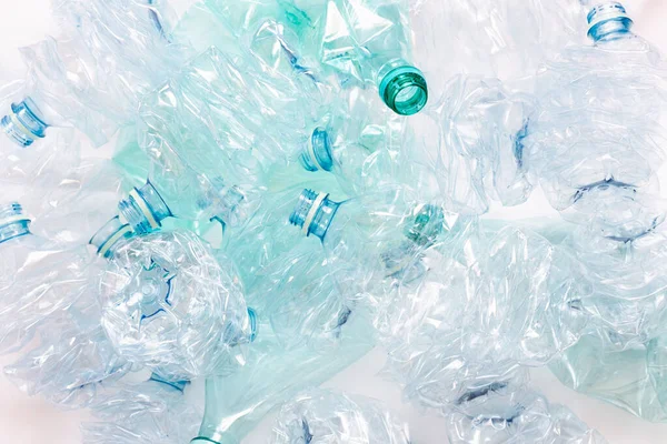 Hafif arka planda ezilmiş plastik şişeler. Çevre kirliliğinin, geri dönüşüm sorunlarının ve başarıların sembolü