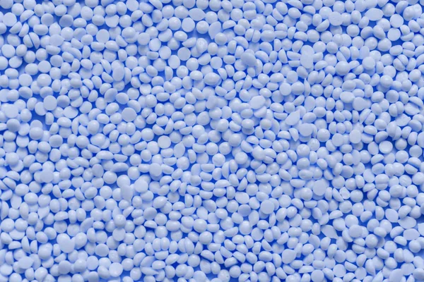 Mavi plastik sakız tanecikleri yığını. Granüler doku arka planı. 2020 'nin klasik mavi rengi