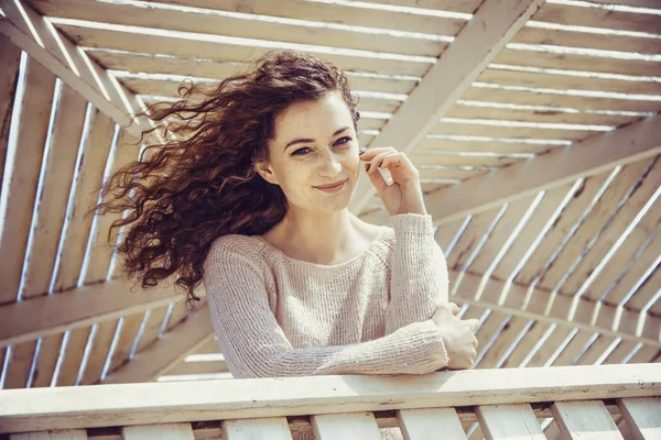 Chica rizada sonriendo con felicidad en una alcoba soleada primer plano —  Fotos de Stock