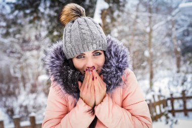 Kış. Kız esmer kapaksız gülümsüyor kar arka plan üzerinde. Yakın çekim
