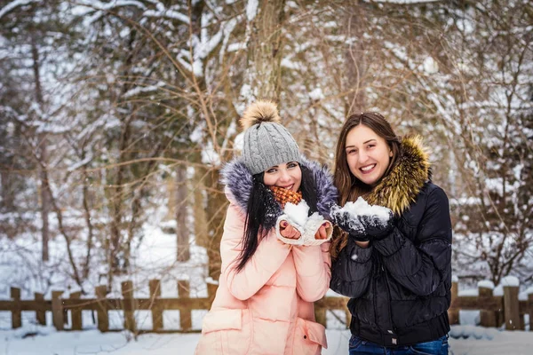 2 meninas estão segurando neve e sorrindo — Fotografia de Stock