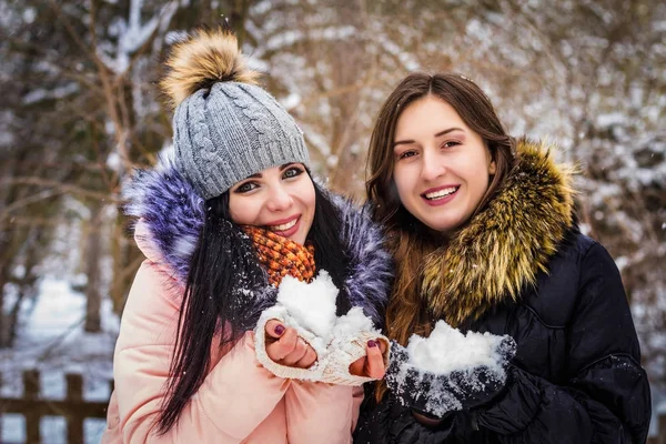 2 дівчини тримають сніг і посміхаються — стокове фото