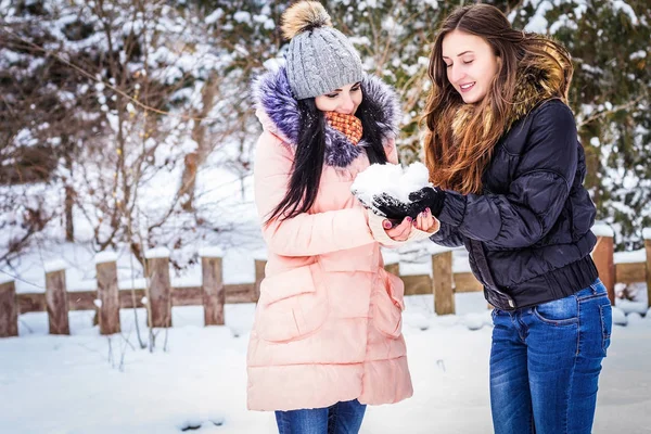 2 meninas estão segurando neve e sorrindo — Fotografia de Stock