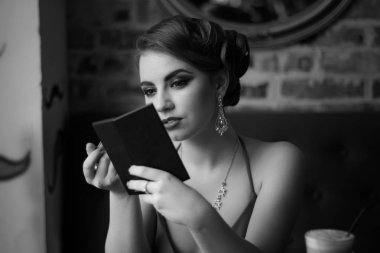 Retro görüntü. Kız kırmızı ruj dudakları boyar. Yakın çekim. Siyah ve beyaz fotoğraf