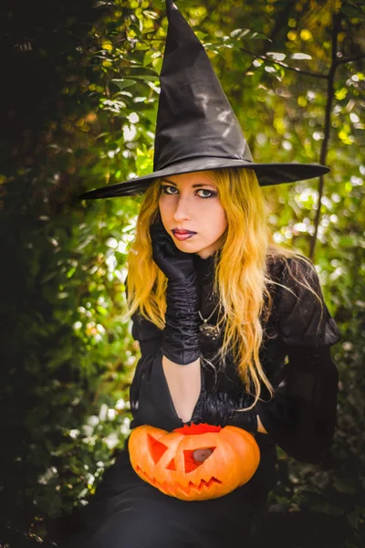 Happy halloween witch girl keeps orange pumpkin — Stock Photo, Image