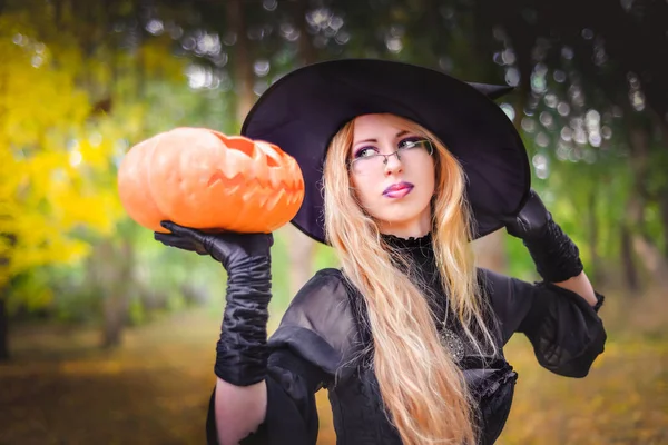Щасливий Хеллоуїн відьма дівчина тримає апельсиновий гарбуз — стокове фото