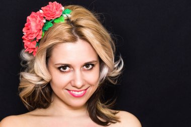 Döşeme ve karanlık bir arka plan üzerinde kırmızı çiçekli rimmed sarışın kadınla 