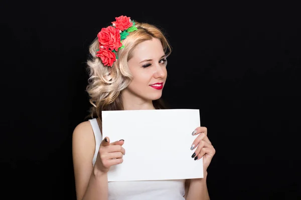 Frau mit blonden Locken und rotem Lippenstift am Rand mit roten Blumen hält — Stockfoto