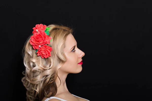 Mulher com colocação loira e repleto de flores vermelhas em um fundo escuro — Fotografia de Stock