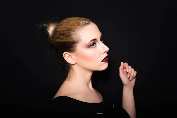 Rubia con el pelo recogido en un moño y maquillaje profesional con labios de color rojo oscuro — Foto de Stock