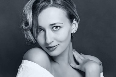 Karanlık bir arka plan üzerinde kısa bir şık saç kesimi ile sarışın kız