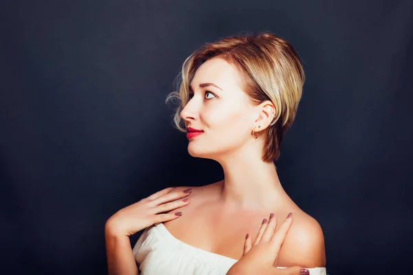 Ragazza bionda con un taglio di capelli corto ed elegante su uno sfondo scuro — Foto Stock