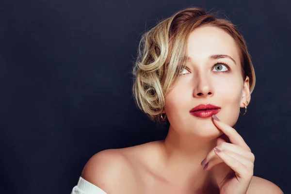 Blondes Mädchen mit kurzem stylischem Haarschnitt auf dunklem Hintergrund — Stockfoto