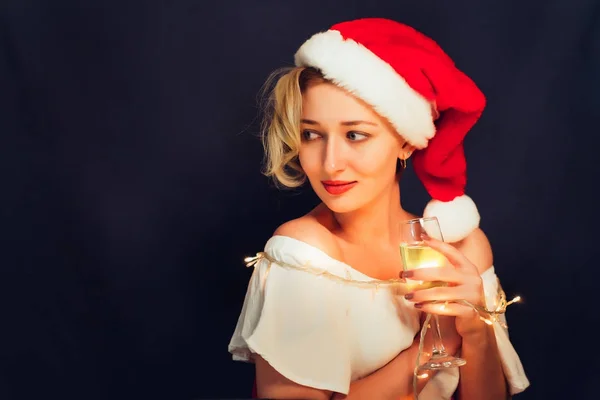 Beautiful blonde close-up in a Santa Claus hat with a glass — Stock Photo, Image