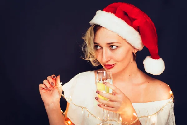 Beautiful blonde close-up in a Santa Claus hat with a glass — Stock Photo, Image