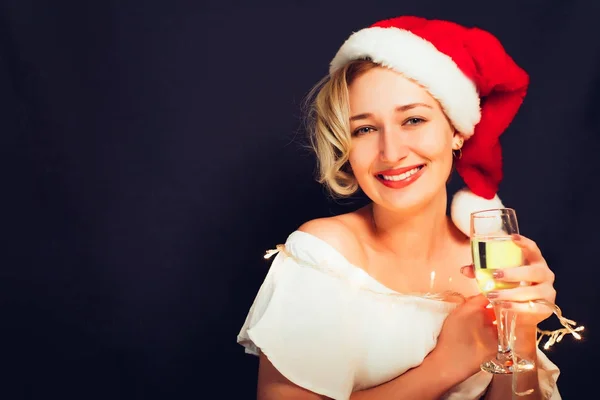 Beautiful blonde close-up in a Santa Claus hat with a glass — Stock Photo, Image