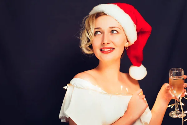 Beautiful blonde close-up in a Santa Claus hat with a glass — Stock Photo, Image