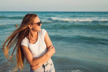 Deniz günbatımının arka planında bir kız