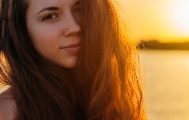 Gün batımında uzun saçlı bir kadın portresi 