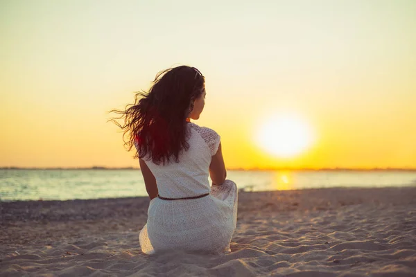 Brunette girl on the background of the sea sunset — Stock Photo, Image