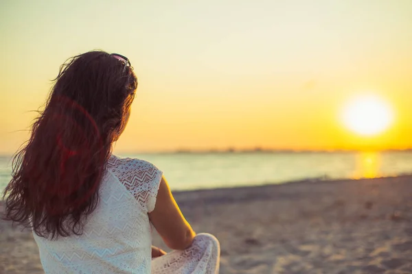 Brunette fille sur le fond de la mer coucher de soleil Photo De Stock