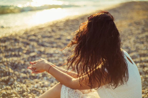 Brunette fille sur le fond de la mer coucher de soleil Image En Vente