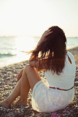 Esmer kız deniz günbatımının arka planında