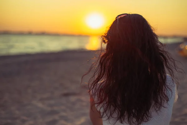 Brünettes Mädchen auf dem Hintergrund des Meeres Sonnenuntergang Stockbild