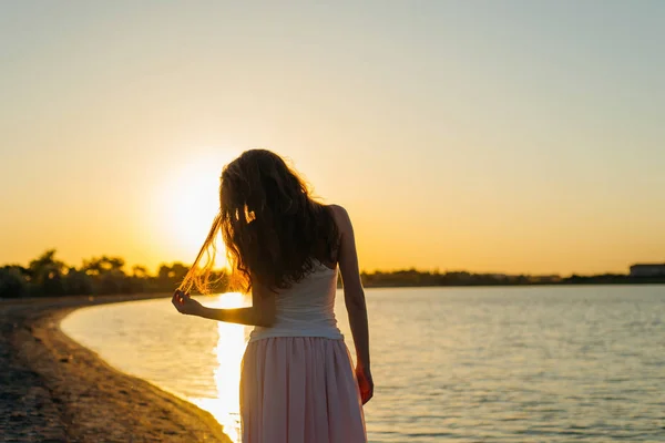 Femme aux cheveux longs au coucher du soleil Photos De Stock Libres De Droits